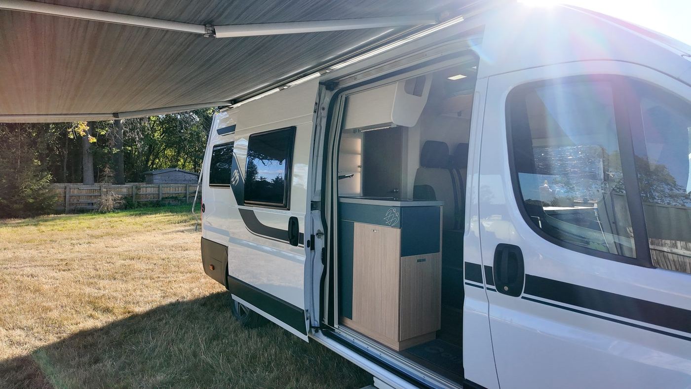 The KNAUS with its awning out on a summer evening